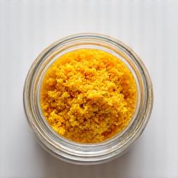 Yis nutrisi serbuk kuning keemasan di dalam balang kaca.