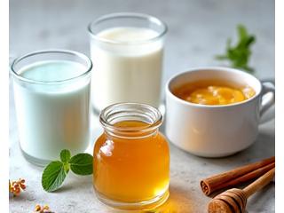 Air kelapa, susu badam, yogurt, madu, dan kayu manis dikelilingi oleh sudu dan bahan pemanis semula jadi.